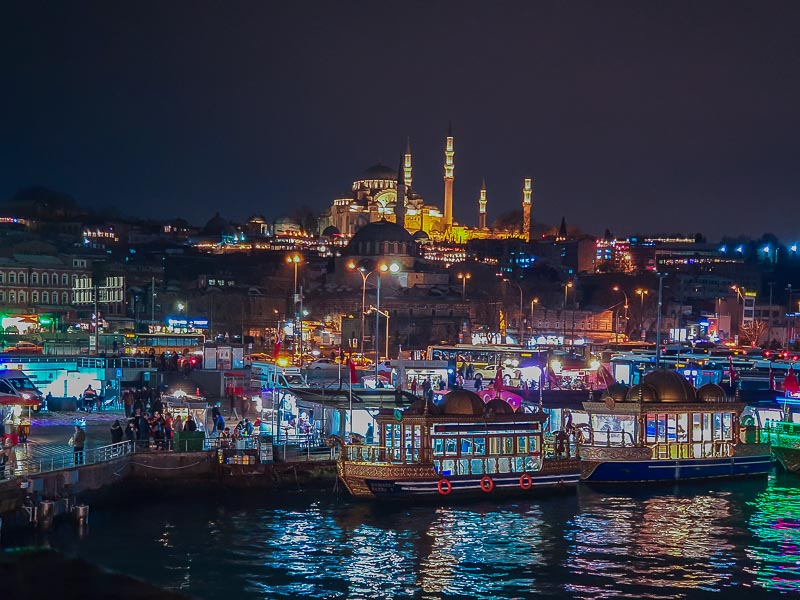 Mercado de comida del mar sobre las orillas del lado europeo a la noche Al fondo se ve la Mezquita Nueva.